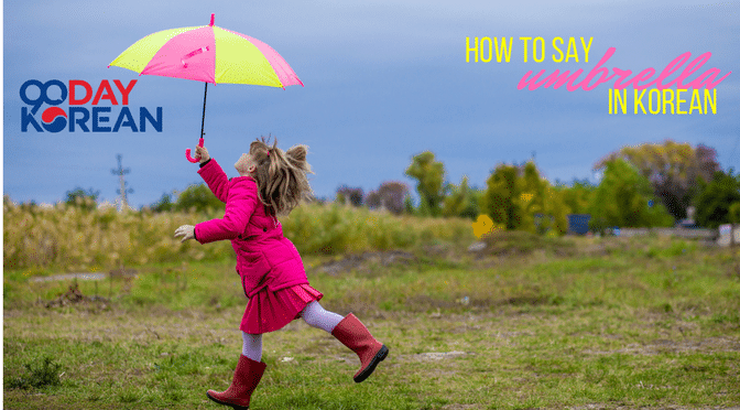 A little girl running in a field with a colorful umbrella