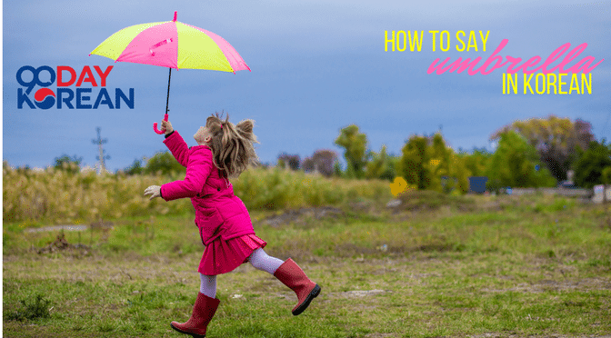 A little girl running in a field with a colorful umbrella