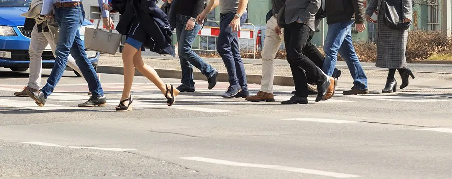 A Crowd Of Pedestrians Crossing Street In The City