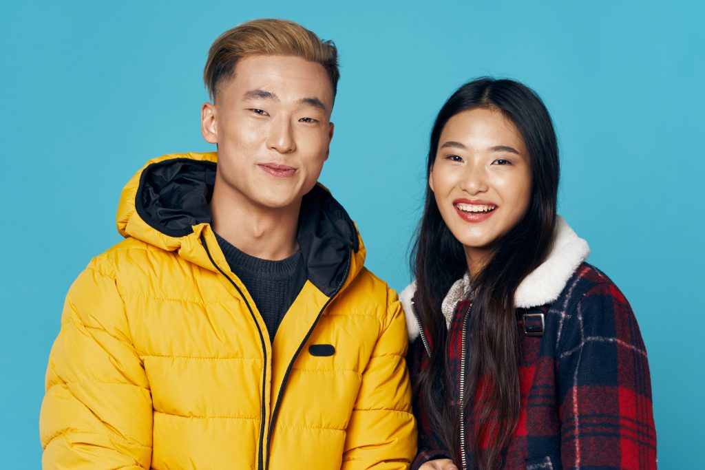 Man And Woman Asian Appearance Winter Clothing Blue Background