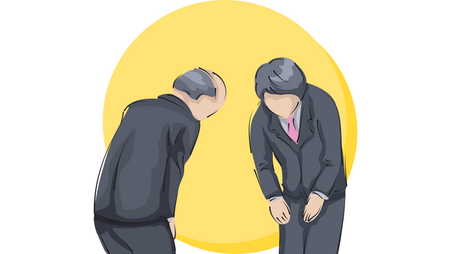Two men in suits bowing at each other